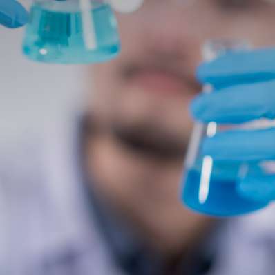 stock photo of a scientist looking at vials