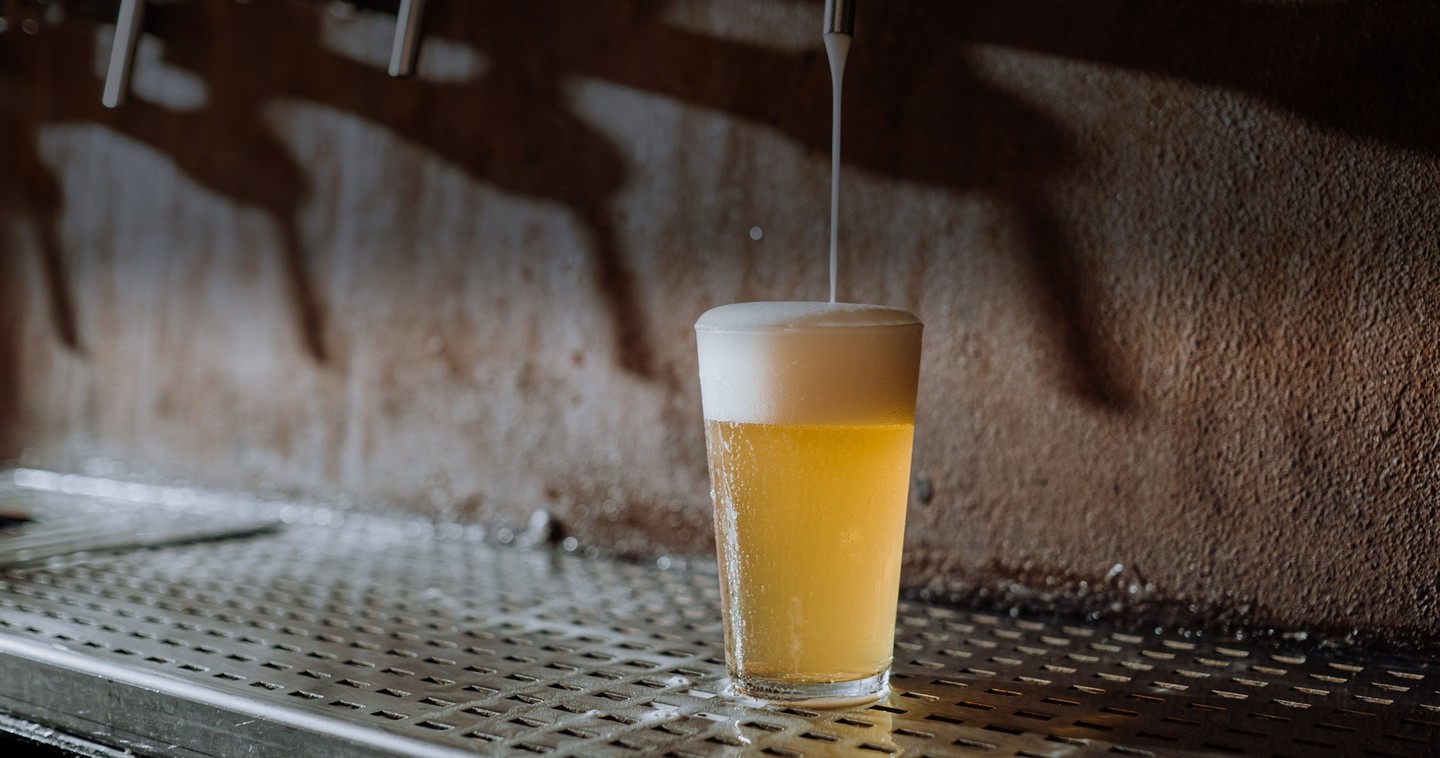 A pint of beer being poured from a draft system