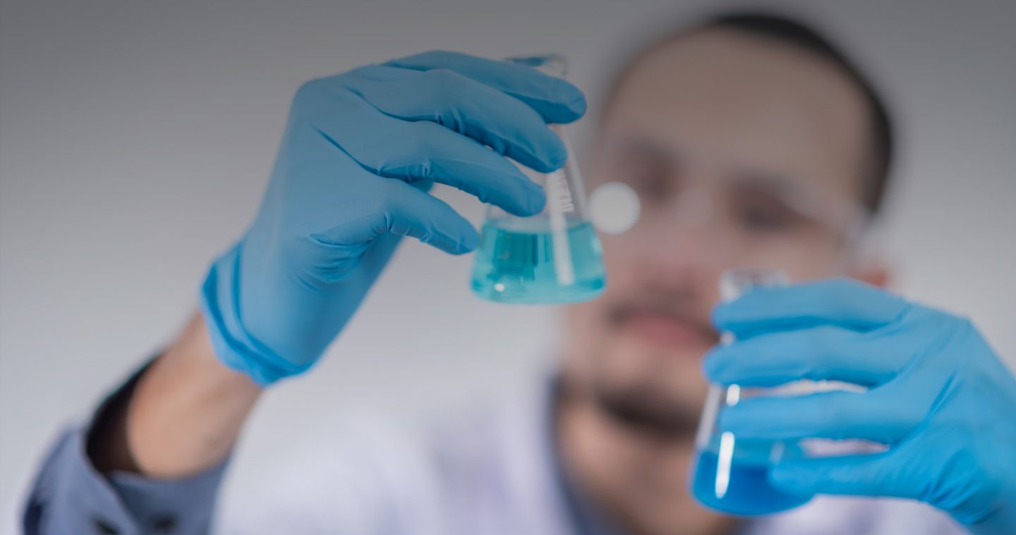 stock photo of a scientist looking at vials